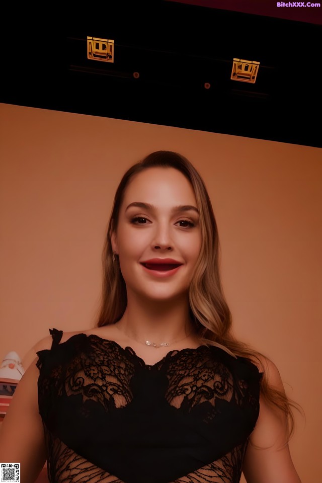 A woman in a black dress posing for a picture.