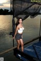 A woman standing on a dock next to a body of water.