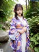 A woman in a purple and white kimono posing for a picture.